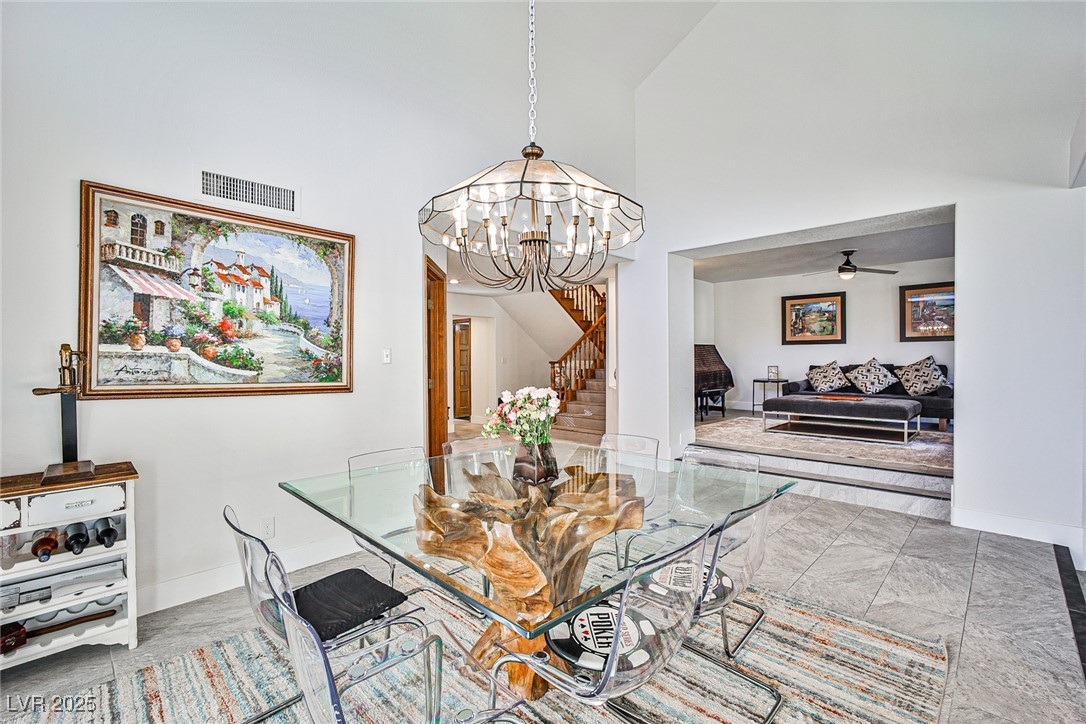 7772 Boca Raton Drive Las Vegas, NV 89113 - Photo 15 of 40 Dining space featuring a high ceiling, ceiling fan, a chandelier, and stairs