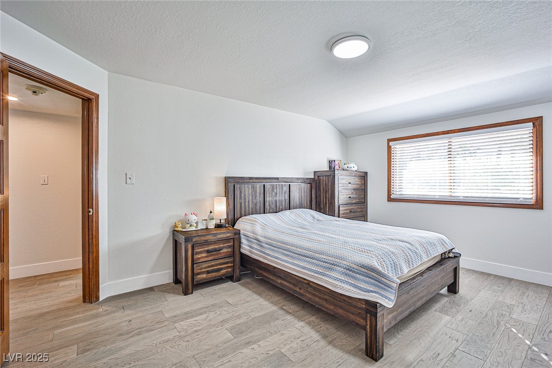7772 Boca Raton Drive Las Vegas, NV 89113 - Photo 28 of 40 Bedroom with light wood finished floors and a textured ceiling