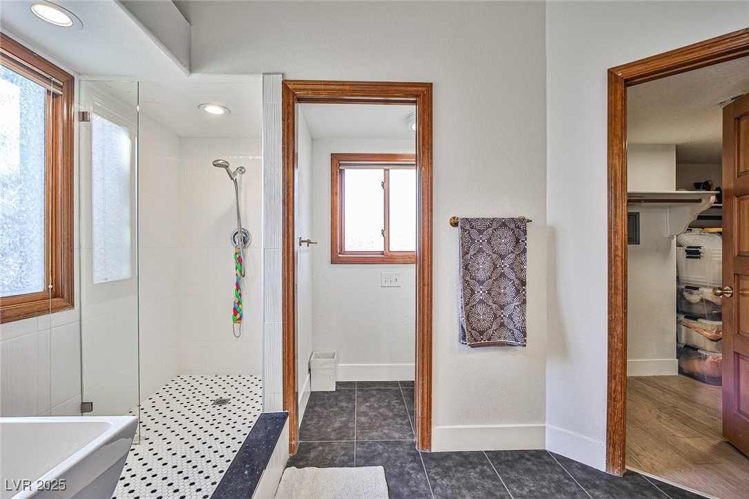 7772 Boca Raton Drive Las Vegas, NV 89113 - Photo 34 of 40 Full bathroom with a stall shower, dark tile patterned floors, and a freestanding tub