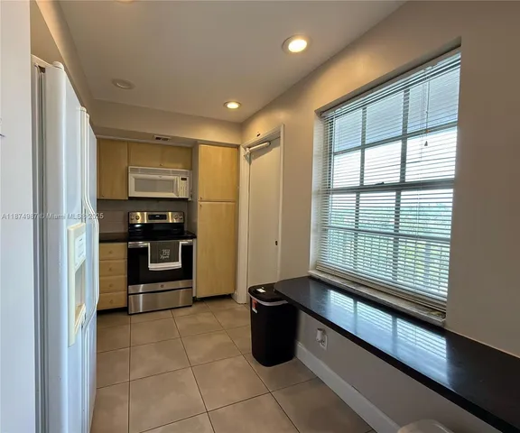 a kitchen with stainless steel appliances granite countertop a refrigerator and a stove top oven