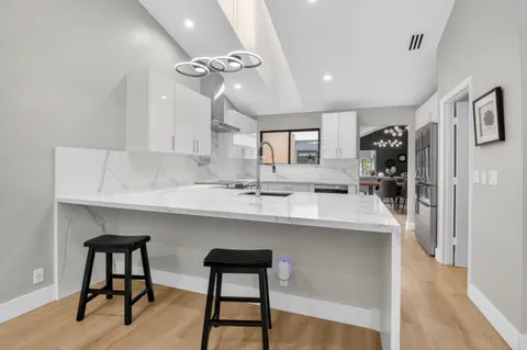 a kitchen with kitchen island a appliances dining table and chairs