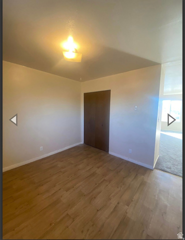 106 East Richelman Lane Wellington, UT 84542 - Photo 21 of 35 Unfurnished bedroom with wood finished floors and a closet