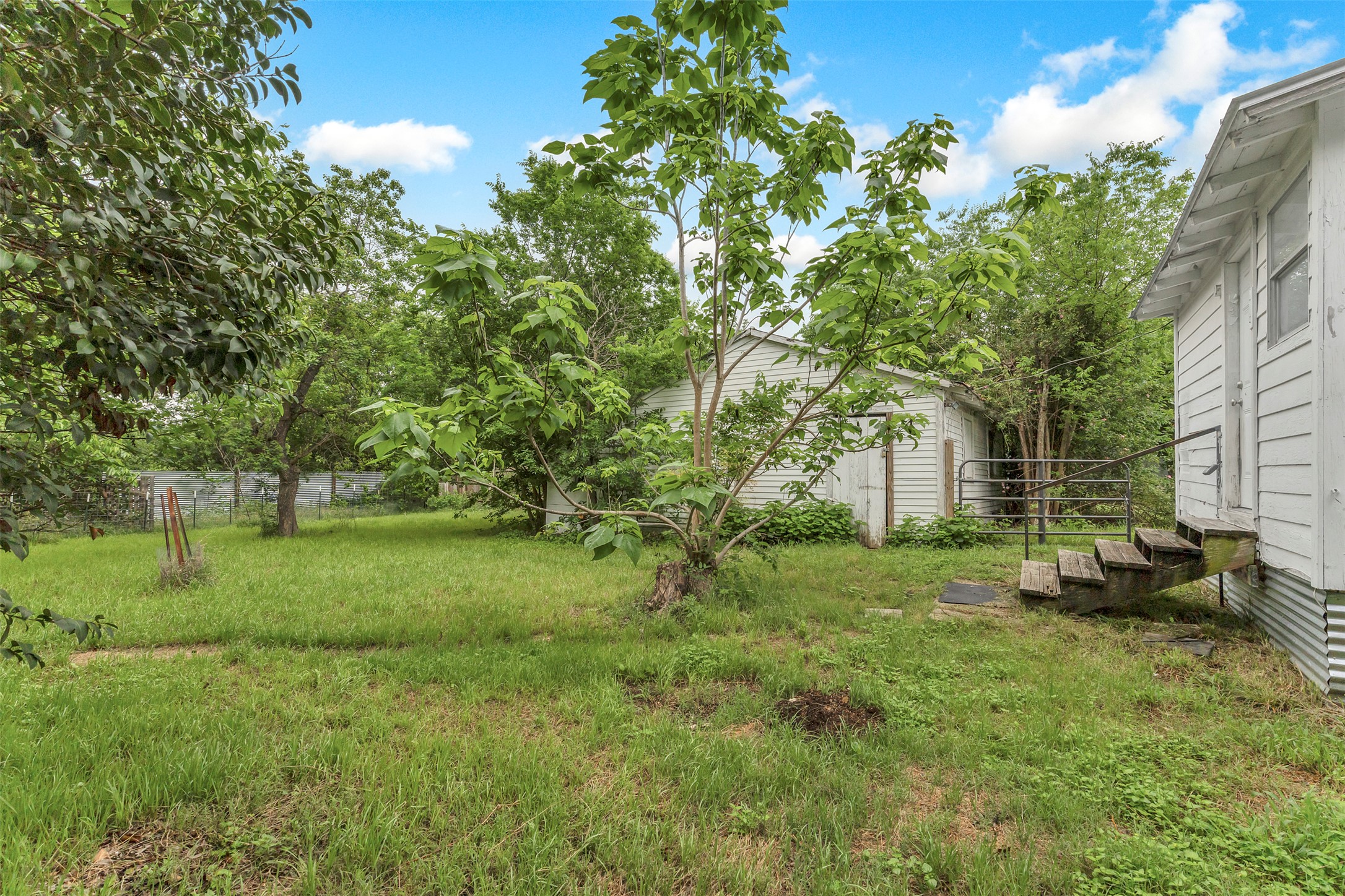1002 Washburn Street Taylor, TX 76574 - Photo 25 of 29 The property features an extensive green yard with mature trees