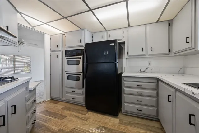a kitchen with a refrigerator and a stove top oven