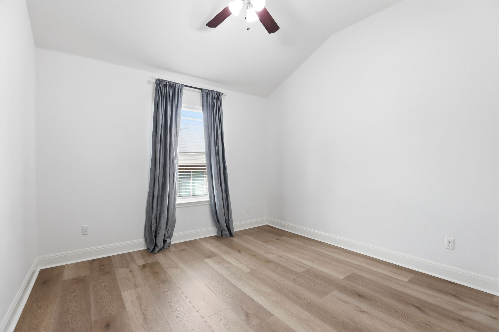 152 Stone View Trail Austin, TX 78737 - Photo 26 of 33 Unfurnished room with lofted ceiling, light wood finished floors, and a ceiling fan