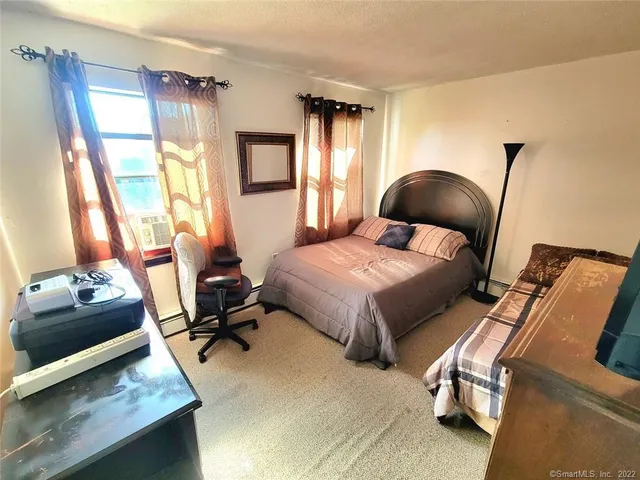 a bedroom with a bed and large windows