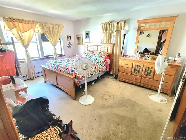 a bedroom with a bed couch and a window