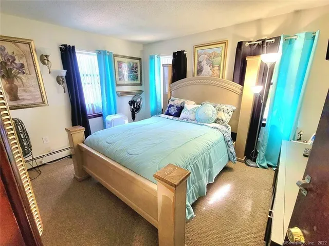 a bedroom with a bed couch and a large mirror