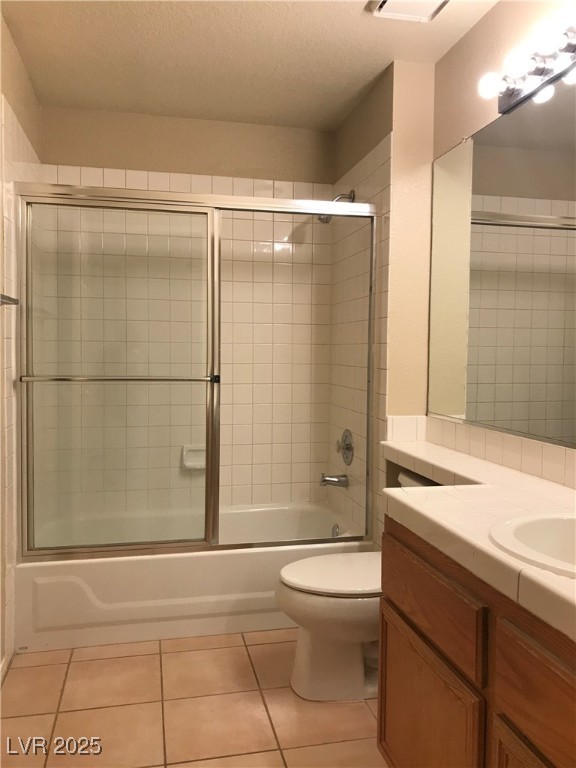 5155 West Tropicana Avenue, Unit 1155 Las Vegas, NV 89103 - Photo 8 of 11 Bathroom with shower / bath combination with glass door, vanity, light tile patterned floors, and a textured ceiling