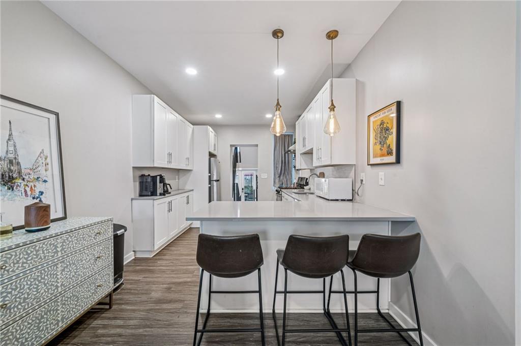 1426 Rush Street Pittsburgh, PA 15233 - Photo 13 of 30 a kitchen with stainless steel appliances kitchen island granite countertop a dining table chairs and a refrigerator