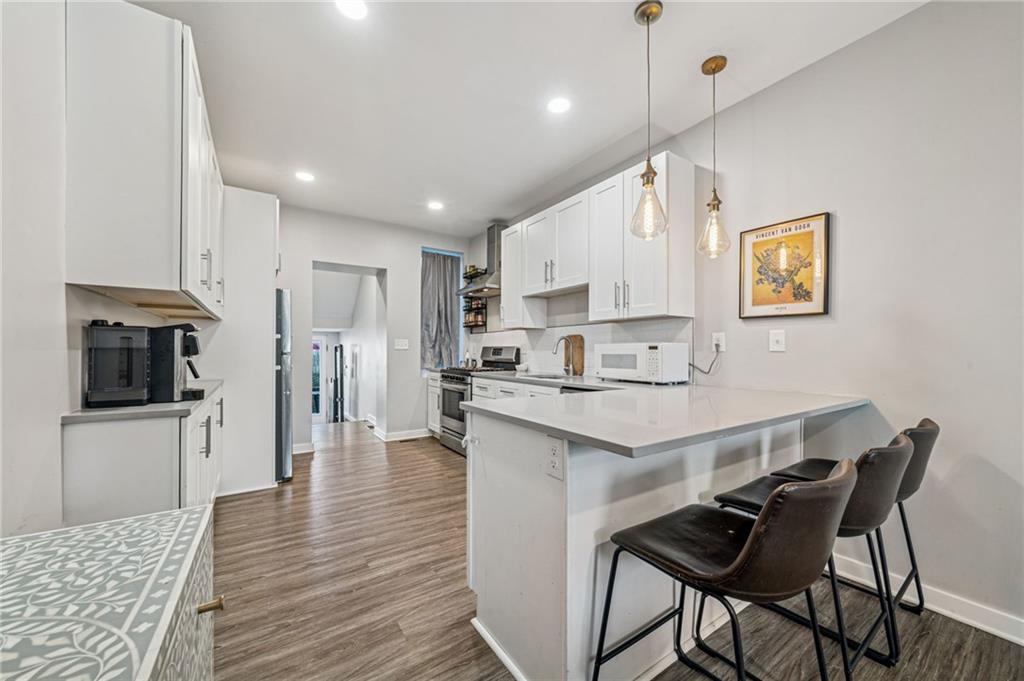 1426 Rush Street Pittsburgh, PA 15233 - Photo 15 of 30 a kitchen with stainless steel appliances kitchen island granite countertop a table chairs refrigerator and microwave