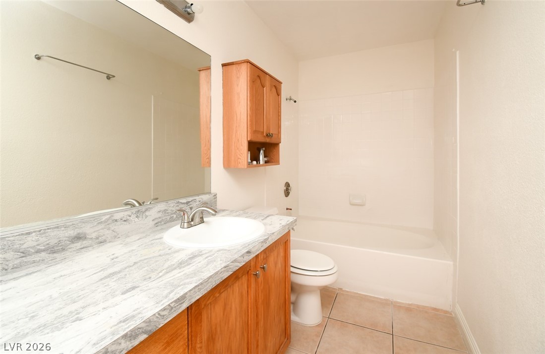 7570 West Flamingo Road, Unit 119 Las Vegas, NV 89147 - Photo 9 of 15 A well-lit bath features a vanity with ample counter space and a full-sized mirror.