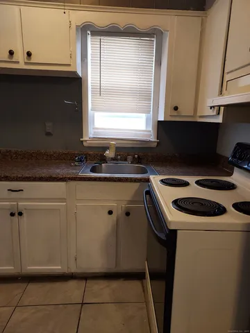 a kitchen with granite countertop white cabinets and white appliances