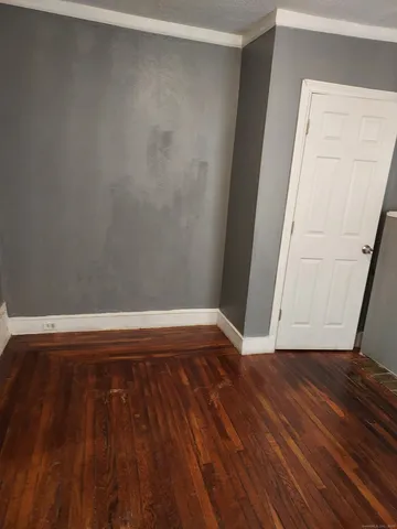 a view of a room with wooden floor and white walls