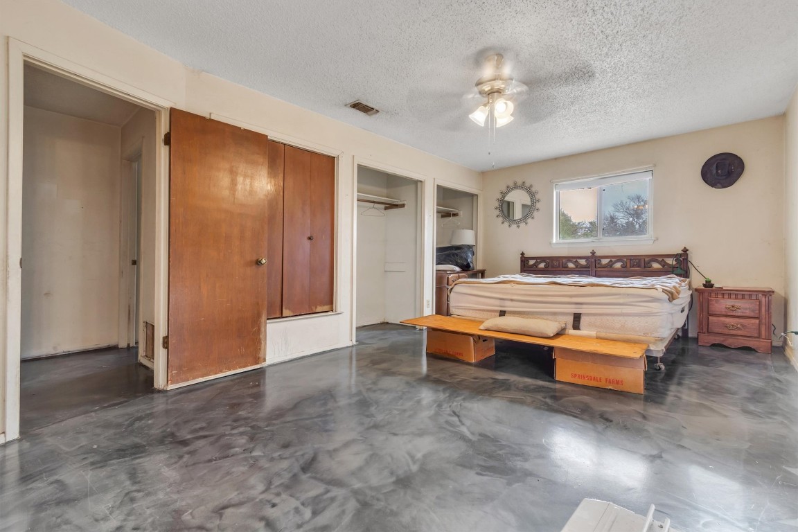 501 County Road 176 Georgetown, TX 78628 - Photo 16 of 33 a spacious bedroom with a bed and a chandelier