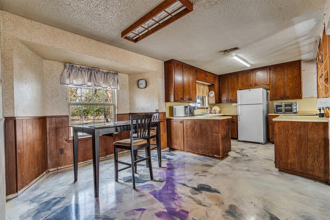 501 County Road 176 Georgetown, TX 78628 - Photo 9 of 33 a kitchen with refrigerator and chairs