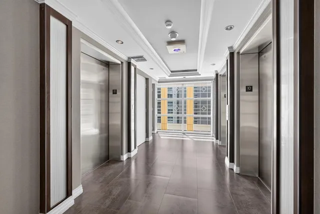 a view of a hallway with wooden floor and windows