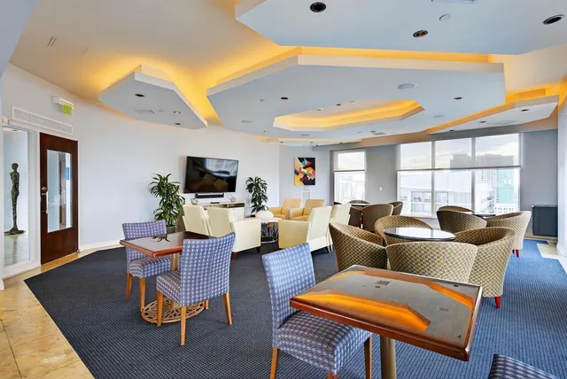 a living room with furniture a flat screen tv and a large window