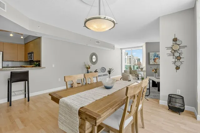 a view of a a dining room with furniture window and wooden floor