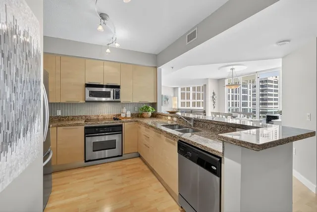 a kitchen with stainless steel appliances granite countertop a sink and stove top oven