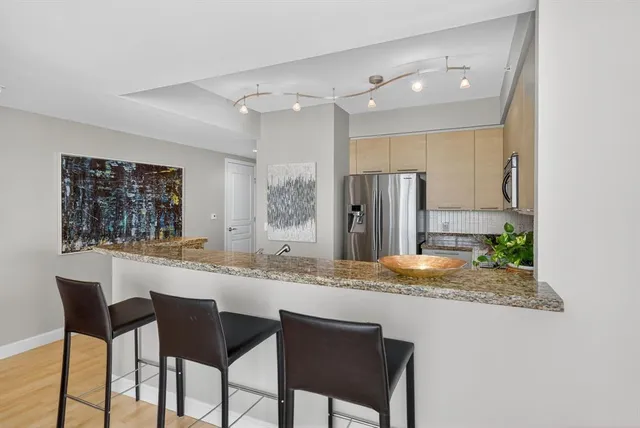a kitchen with stainless steel appliances granite countertop a sink and a refrigerator