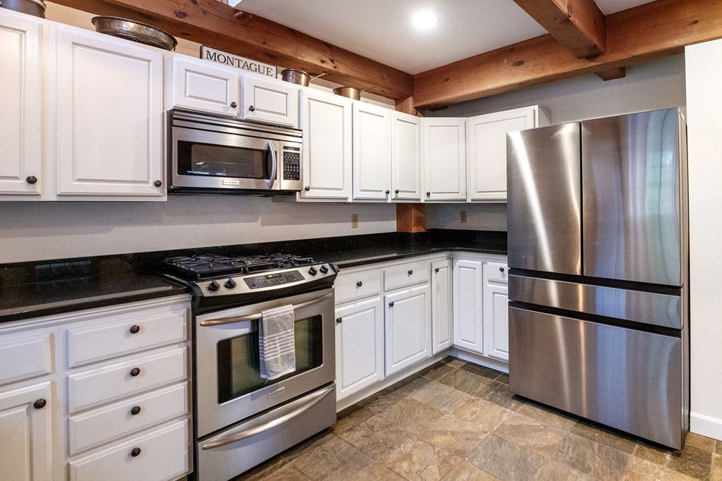 77 Swamp Road Montague, MA 01351 - Photo 14 of 35 a kitchen with stainless steel appliances granite countertop a stove a refrigerator and a microwave