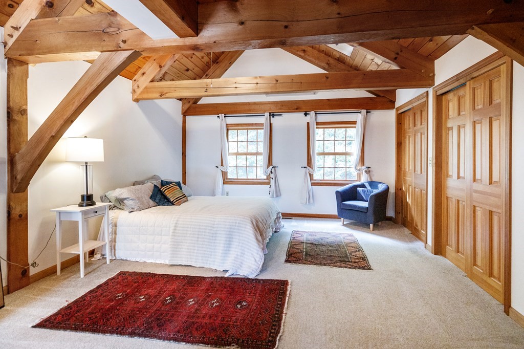 77 Swamp Road Montague, MA 01351 - Photo 21 of 35 a bedroom with a large bed and a chandelier