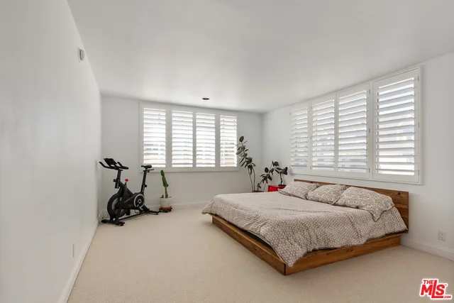 a bedroom with a bed a table and a window