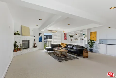 a living room with furniture a fireplace and a window
