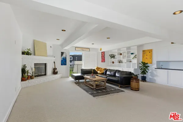 a living room with furniture a fireplace and a window