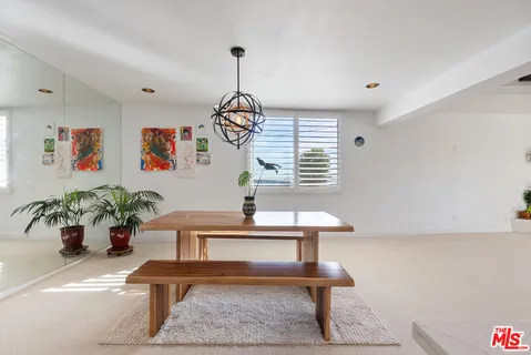 a living room with couches table and a potted plant