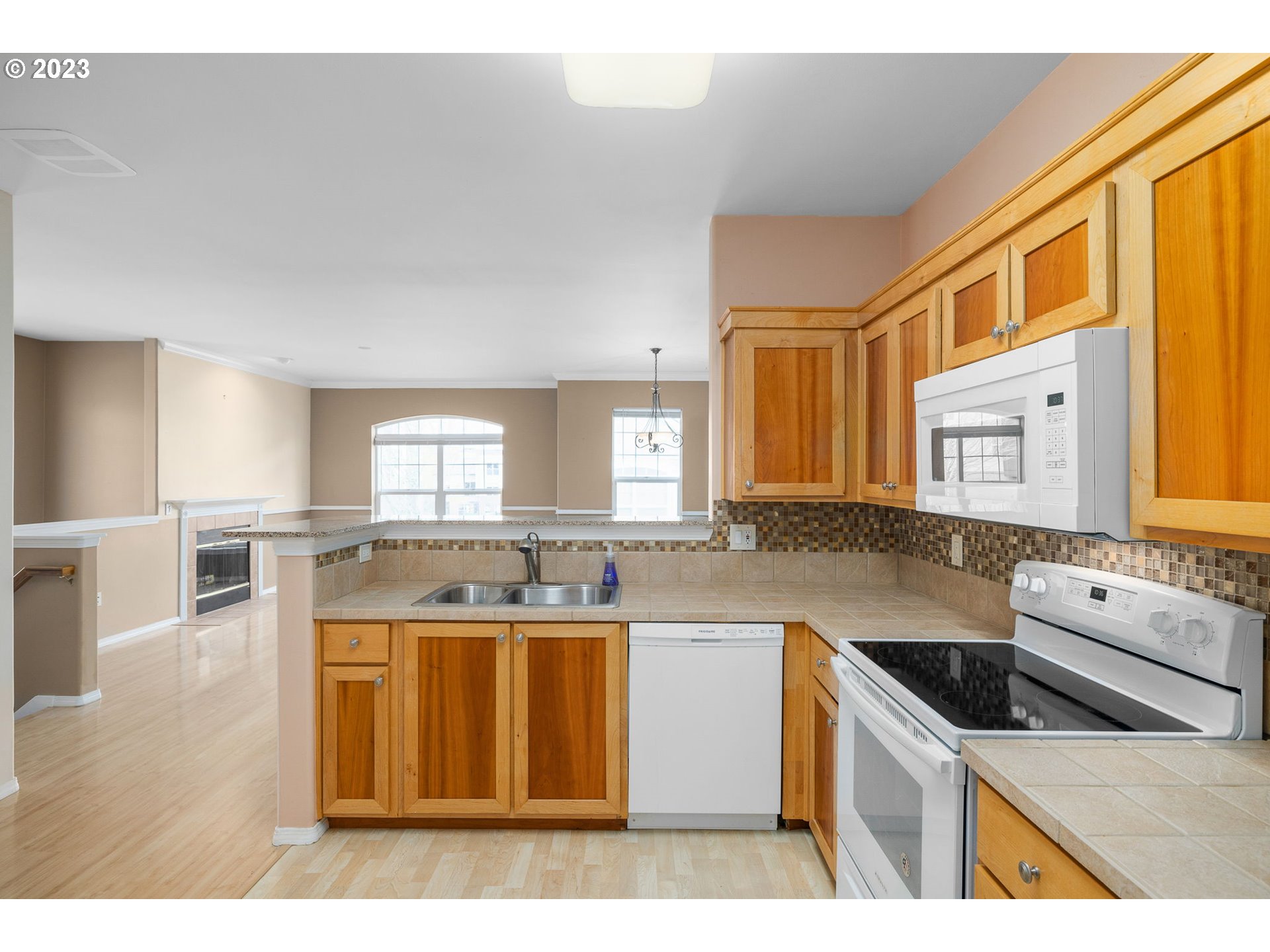 1110 Northeast 63rd Way, Unit 2009 Hillsboro, OR 97124 - Photo 11 of 31 a kitchen with a stove a sink a refrigerator and a dining table
