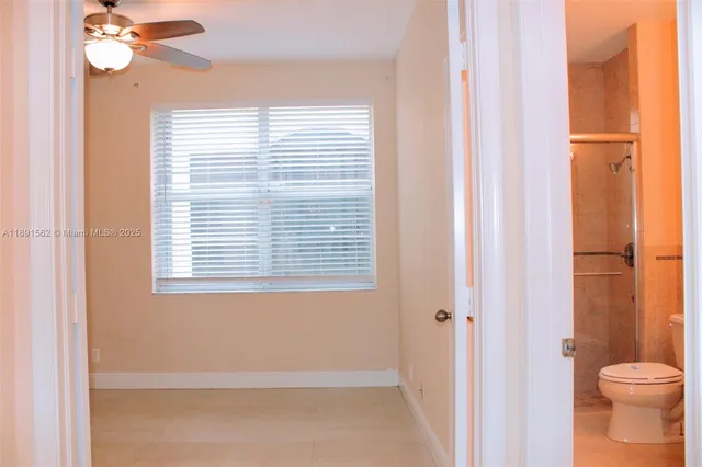 a view of a room with wooden floor and fan