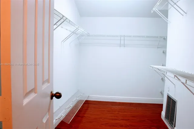 an empty room with wooden floor and a window