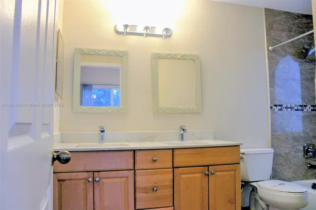 a view of a chandelier in big room with wooden floor and chandelier