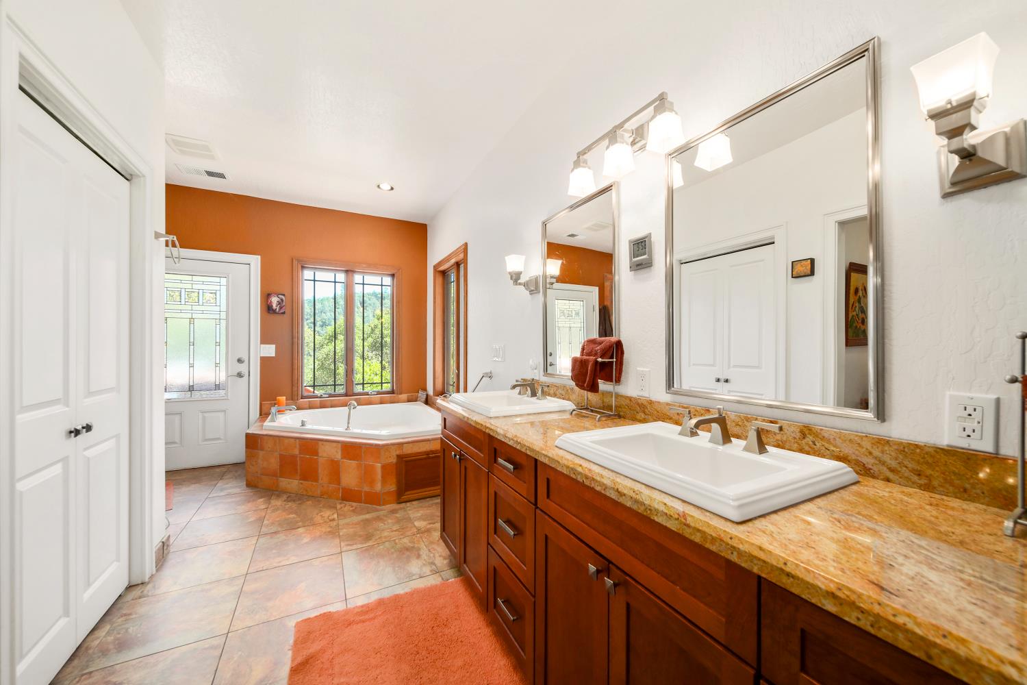 5603 Gold Mountain Road Mountain Ranch, CA 95246 - Photo 27 of 78 a spacious bathroom with a granite countertop sink and a large mirror