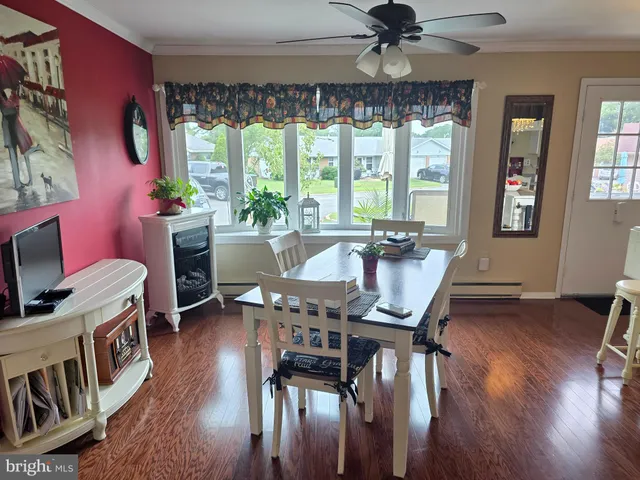 a kitchen with stainless steel appliances a dining table chairs stove and white cabinets