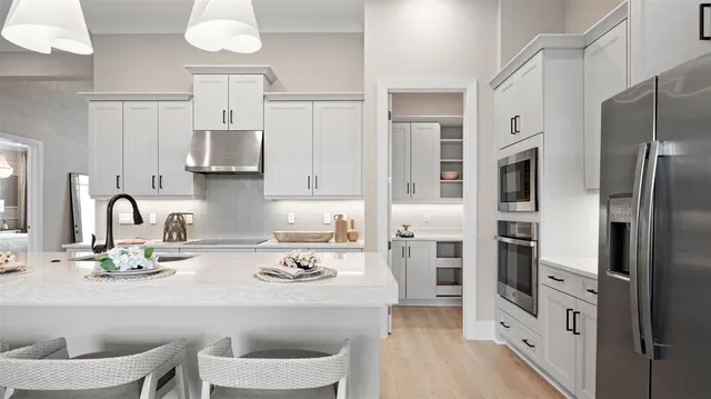a kitchen with stainless steel appliances a refrigerator and a stove top oven