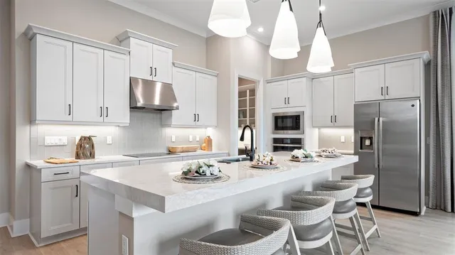 a kitchen with stainless steel appliances a sink stove refrigerator and cabinets