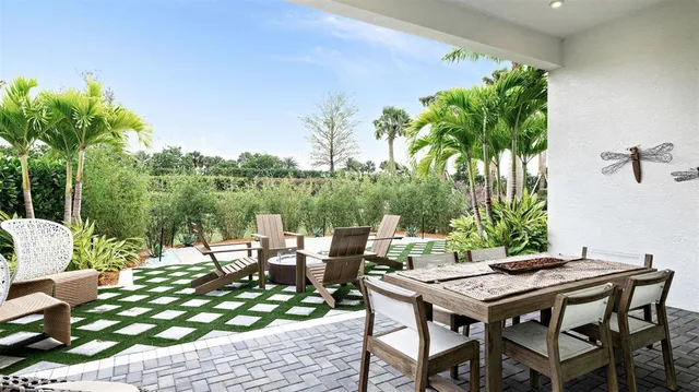 a view of a patio with table and chairs potted plants and palm tree