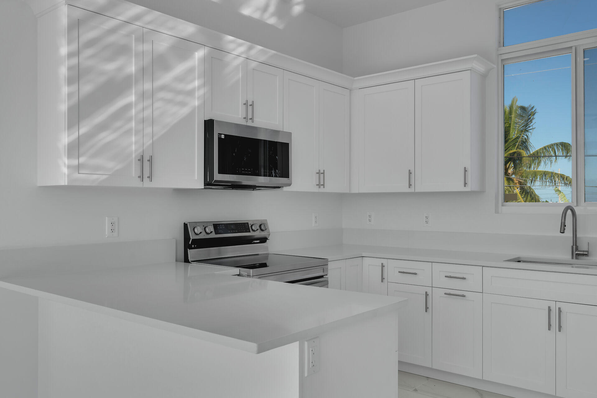 31368 Ave I Big Pine Key, FL 33043 - Photo 13 of 47 a kitchen with stainless steel appliances granite countertop white cabinets a microwave a sink and a white refrigerator