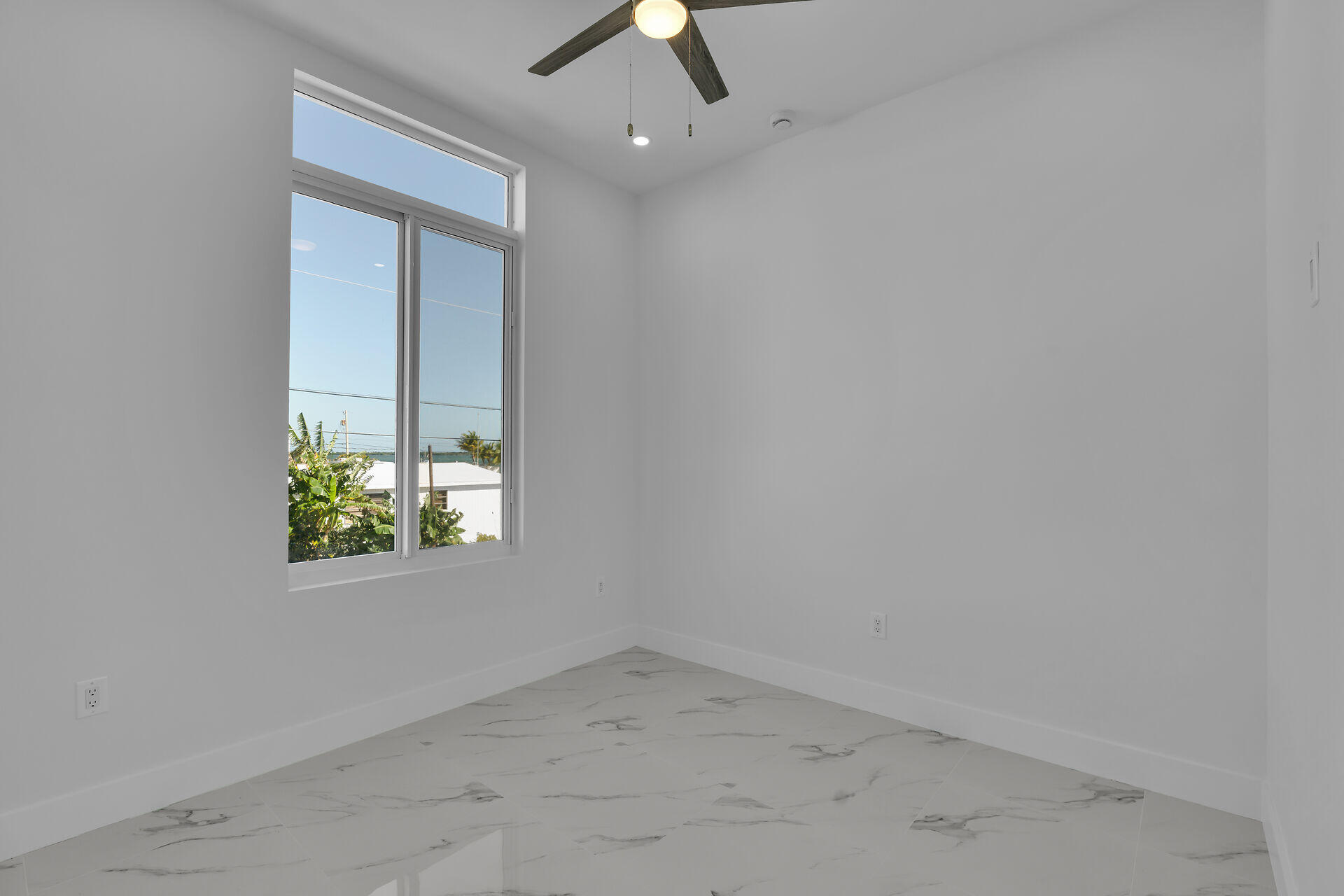 31368 Ave I Big Pine Key, FL 33043 - Photo 27 of 47 an empty room with a window and a ceiling fan