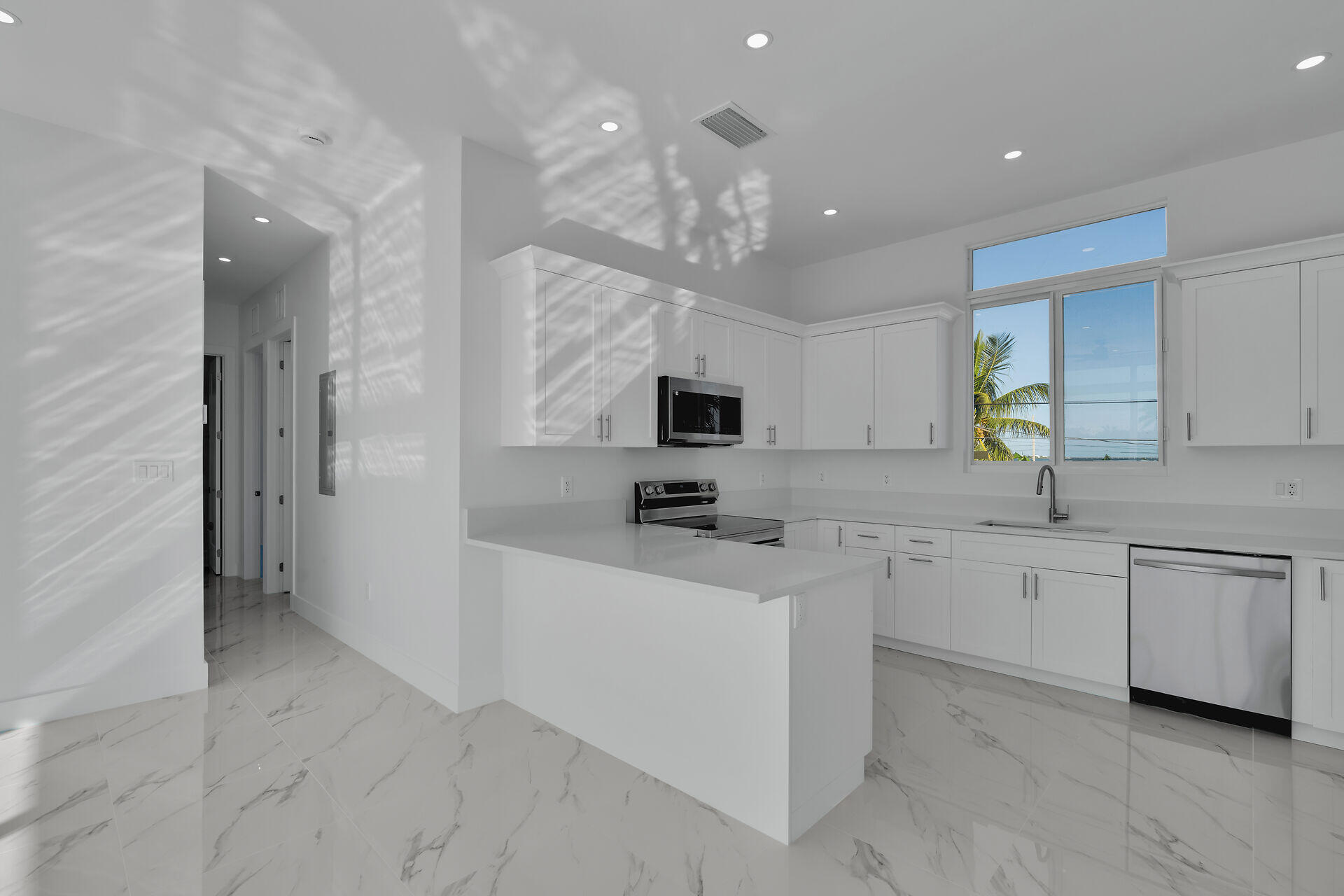 31368 Ave I Big Pine Key, FL 33043 - Photo 10 of 47 a kitchen with white cabinets and chandelier