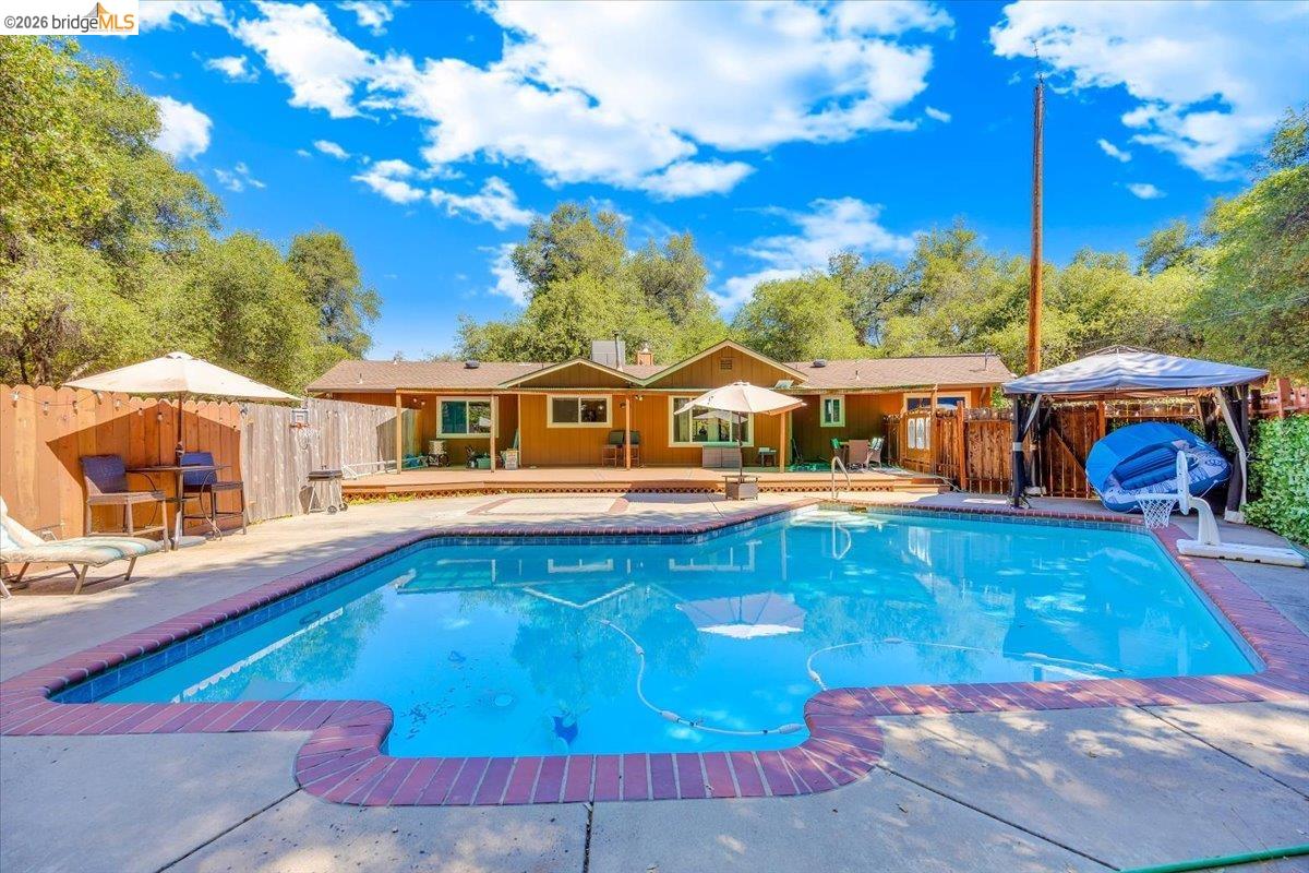 8733 Fraguero Road Sonora, CA 95370 - Photo 57 of 73 Spacious backyard featuring an in-ground swimming pool with brick coping, an expansive wood deck, and a detached gazebo structure