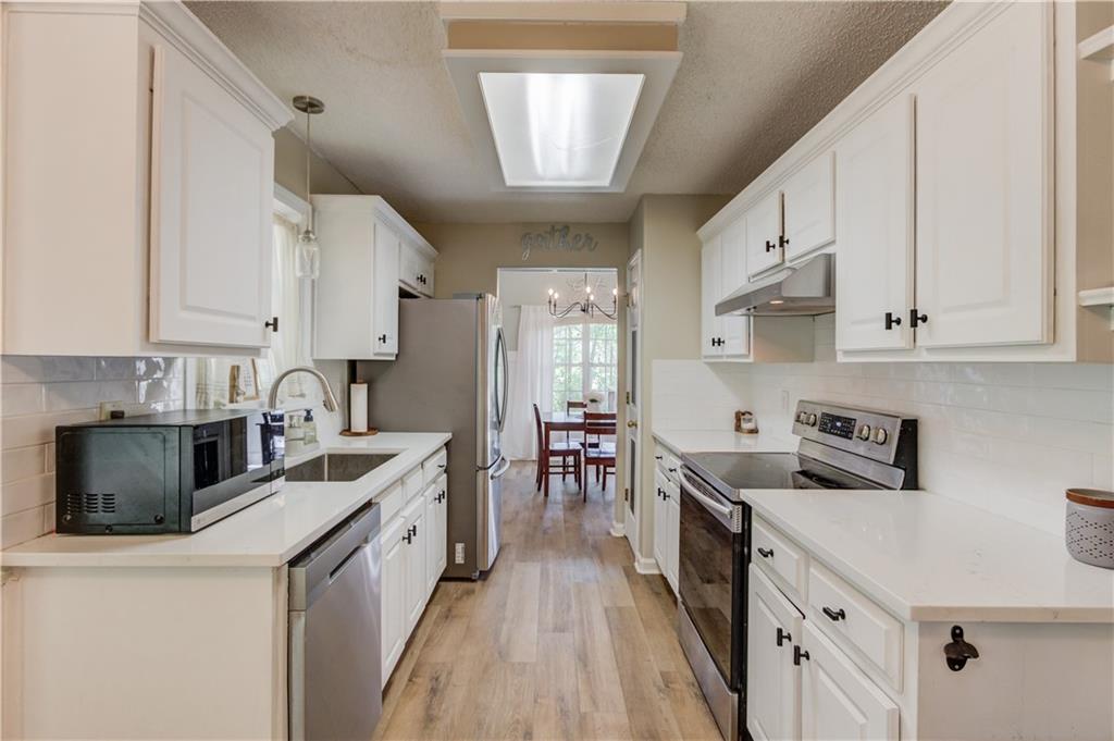 925 Nature Trail Bethlehem, GA 30620 - Photo 17 of 41 a kitchen with stainless steel appliances a stove a sink a stove and white cabinets