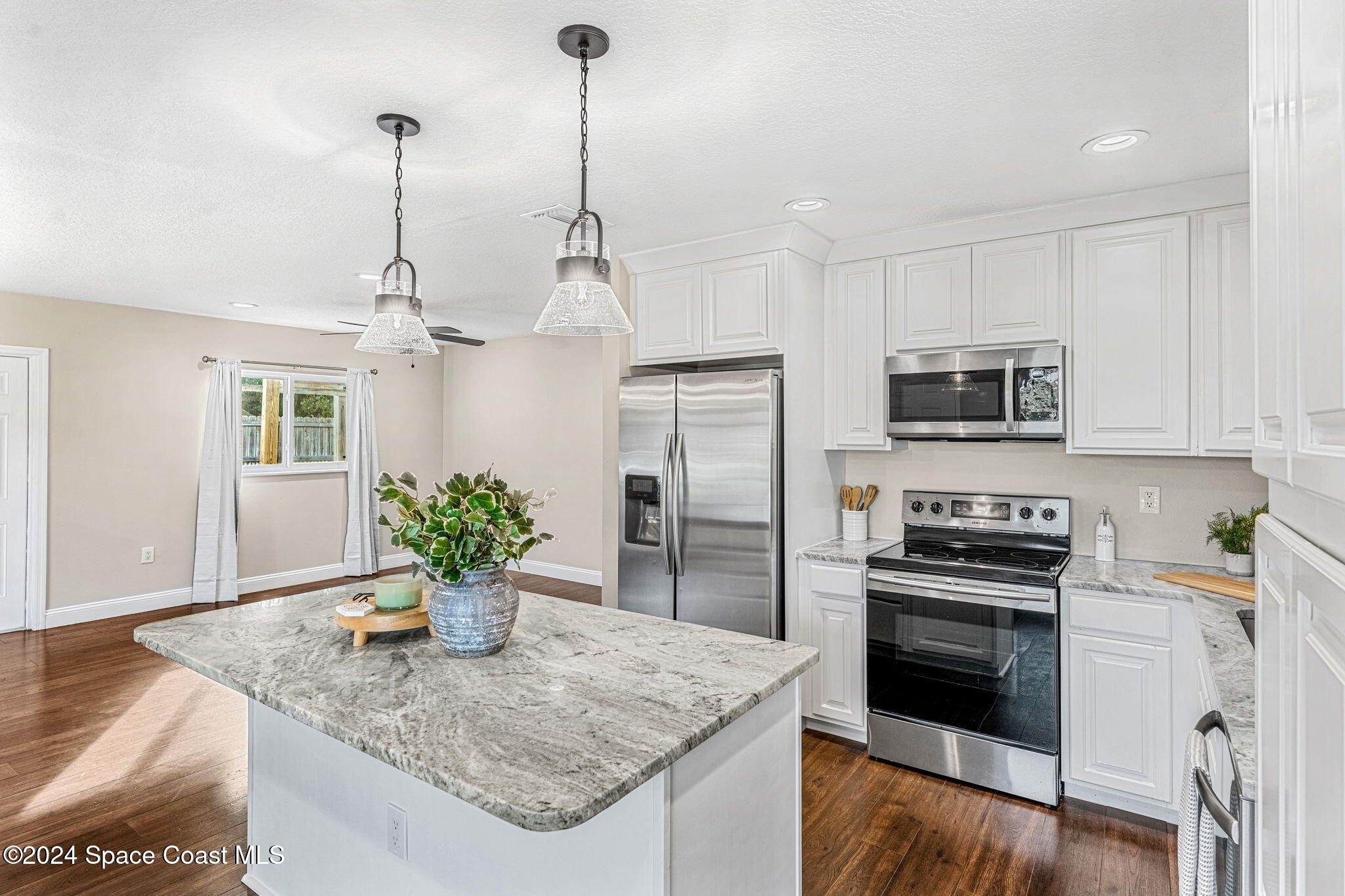 5120 Sutton Avenue Melbourne, FL 32904 - Photo 10 of 38 a kitchen with stainless steel appliances granite countertop a sink a refrigerator a stove a microwave and cabinets