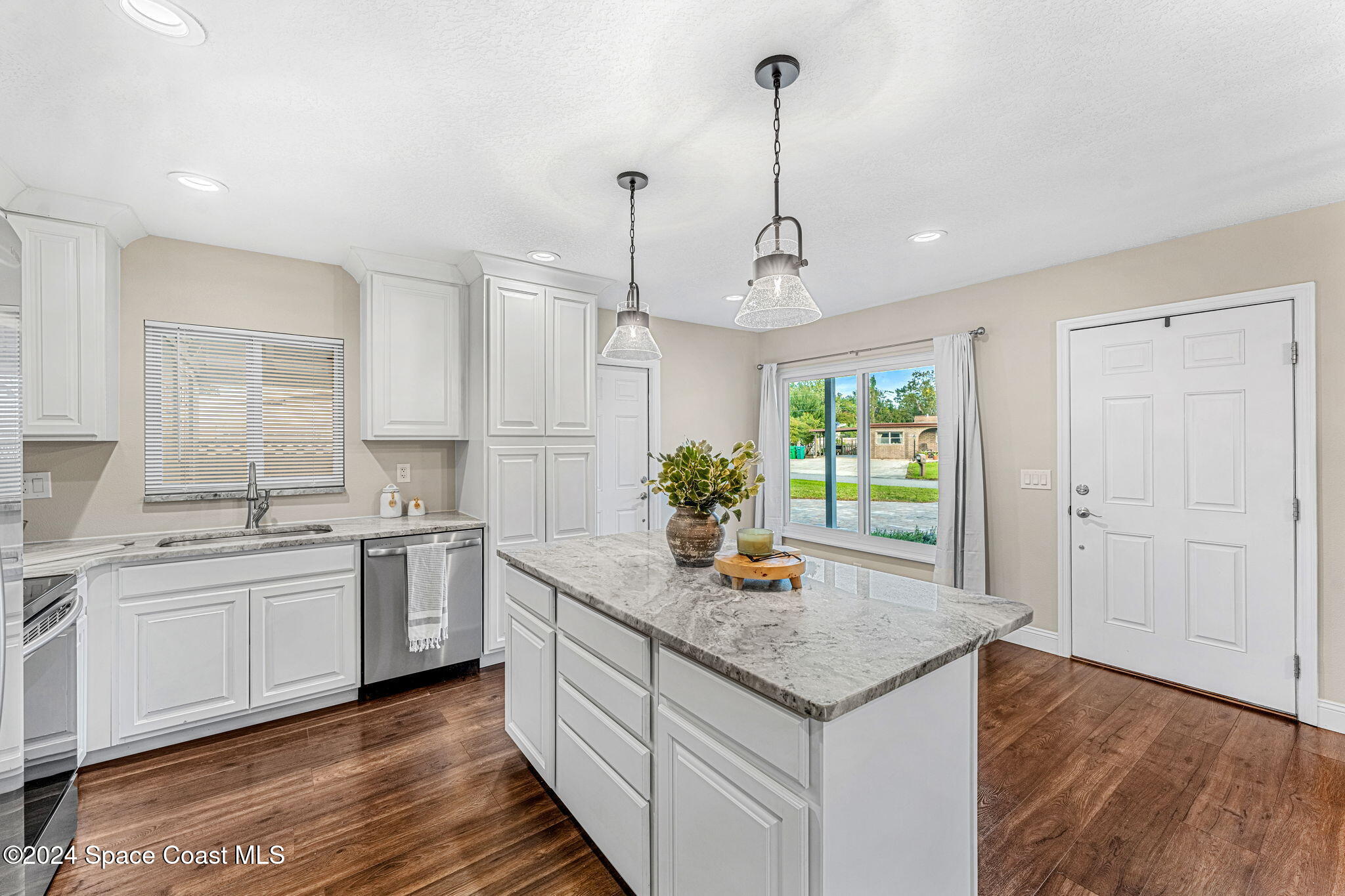 5120 Sutton Avenue Melbourne, FL 32904 - Photo 11 of 38 a kitchen with stainless steel appliances granite countertop a sink a stove and a wooden floors