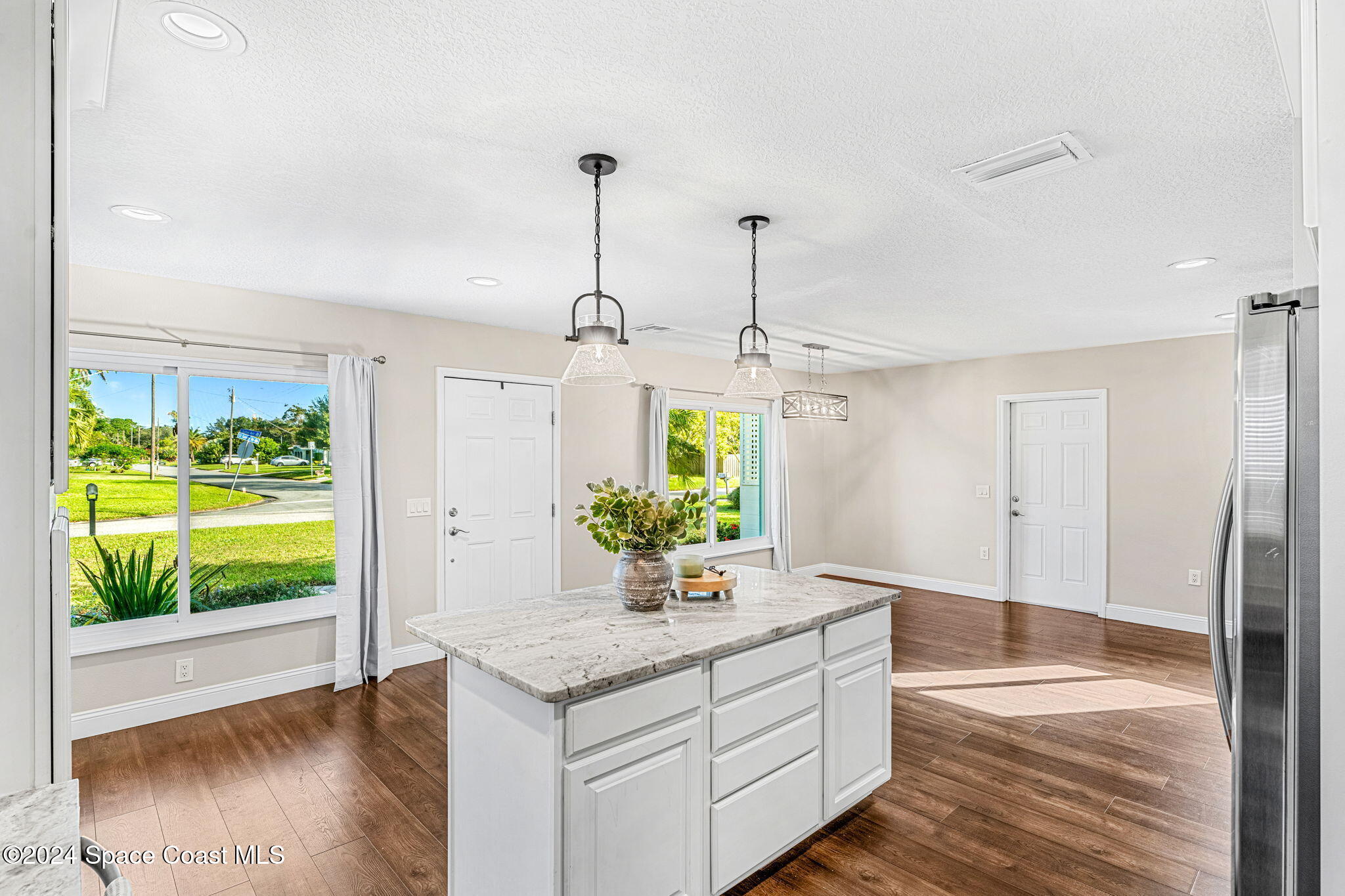 5120 Sutton Avenue Melbourne, FL 32904 - Photo 12 of 38 a living room with a table and a chandelier