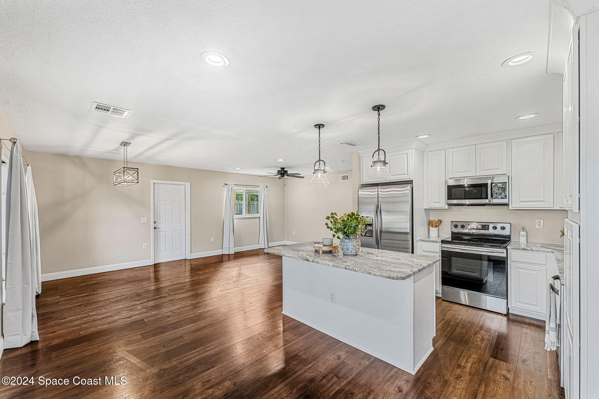 5120 Sutton Avenue Melbourne, FL 32904 - Photo 36 of 38 a kitchen with granite countertop a stove a sink dishwasher and a refrigerator with wooden floor