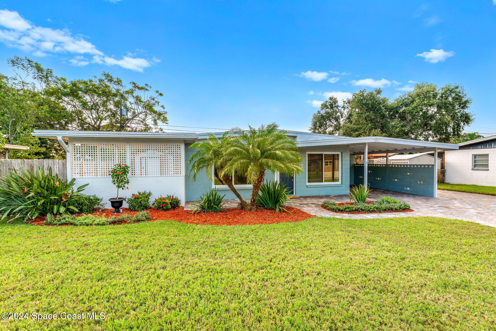 5120 Sutton Avenue Melbourne, FL 32904 - Photo 34 of 38 a front view of a house with a yard and potted plants